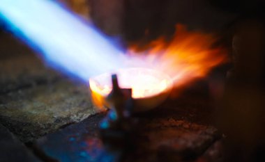 Profesyonel kuyumcu, değerli metali gaz lambasıyla eritiyor..