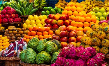 Tezgahta çok çeşitli renkli egzotik meyveler var..