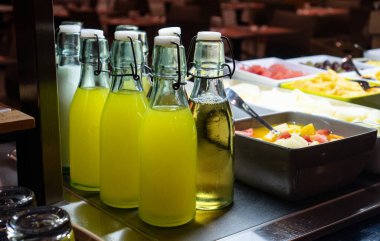 Taze meyve suyu ve sütle dolu cam şişeler..