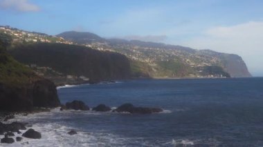 Fırtınalı okyanus dalgaları üzerinde yüksek sarp kayalıklar.