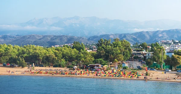 Şezlonglar, şemsiye ve insanlar ile tropikal plaj. — Stok fotoğraf