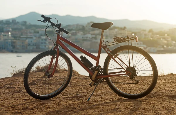 Vélo rouge sur la colline au coucher du soleil . — Photo