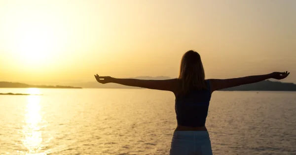 Woman with arms wide open at sunset. — Stock Photo, Image