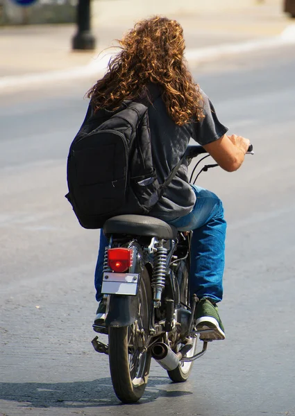 Человек с рюкзаком на мотоцикле. Вид сзади . — стоковое фото