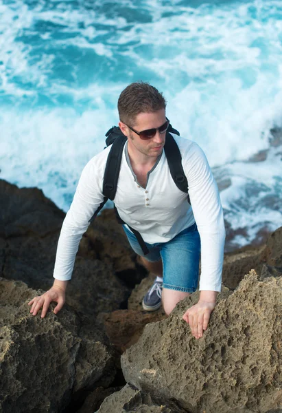 Turista masculino com mochila escalando montanhas . — Fotografia de Stock