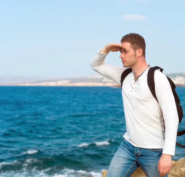 Touriste masculin avec sac à dos debout près de la mer . — Photo