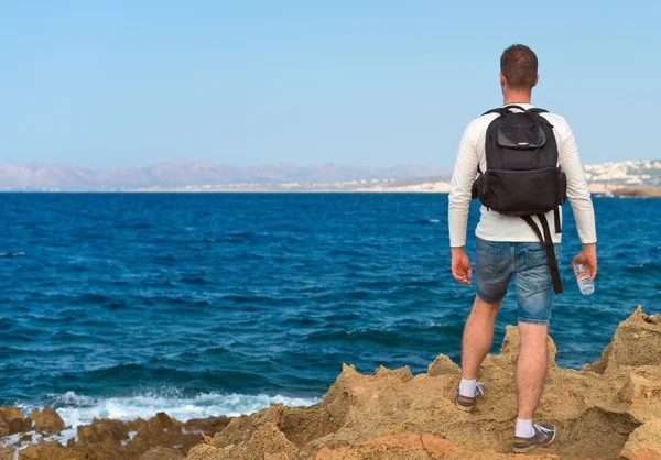 Sırt çantası konumu denize yakın olan erkek turist. Metniniz için yer. — Stok fotoğraf