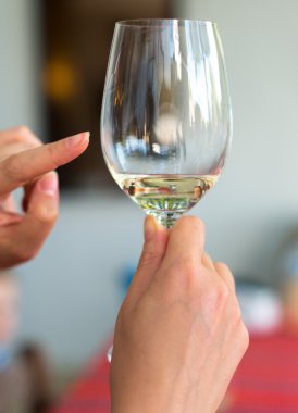 Sommelier bardak beyaz şarap üzerinde gösterir.