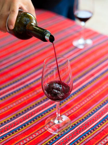 Rotwein wird in Weinglas gegossen. — Stockfoto