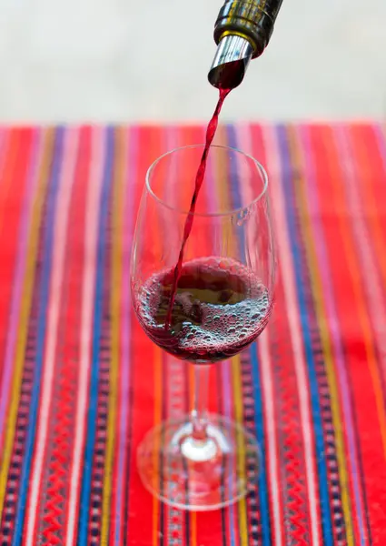 Red wine is pouring into wine glass. — Stock Photo, Image
