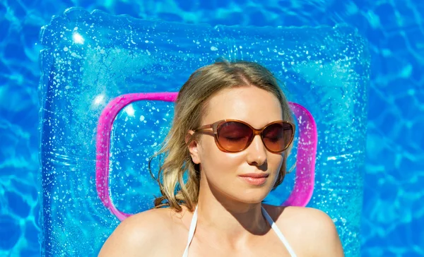 Mulher bonita está tomando sol na piscina . — Fotografia de Stock