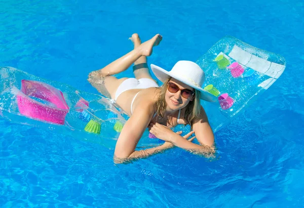 Kvinnan simning på uppblåsbara flotte i vatten pool. — Stockfoto