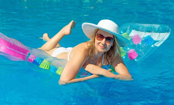 Donna che nuota su zattera gonfiabile in piscina d'acqua . — Foto Stock