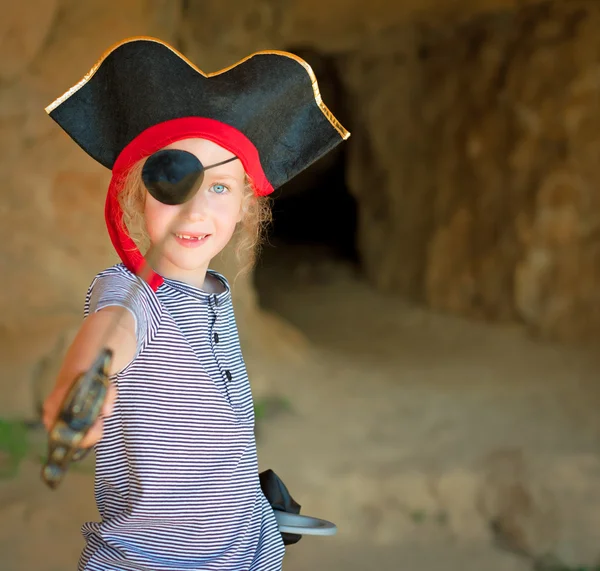 Korsan kostüm mağara girişine yakın kılıç ile küçük kız. — Stok fotoğraf