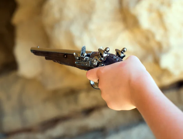 Mano de niño con pistola de mosquete viejo apuntando . — Foto de Stock