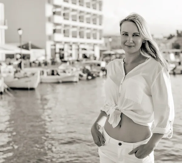 Mujer bonita de pie contra el puerto con yates. Blanco y negro . — Foto de Stock