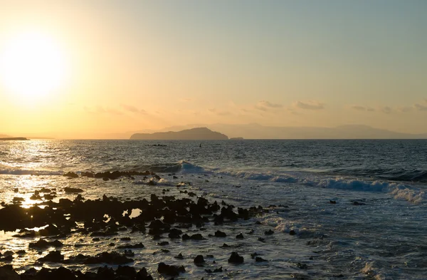 Sunset on the rocky beach in Mediterranean sea. — Stock Photo, Image