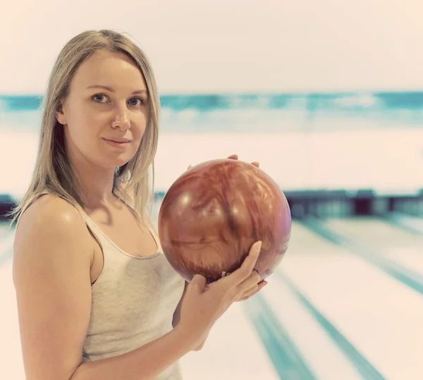 Hezká žena, držení míče v bowling Clubu. — Stock fotografie