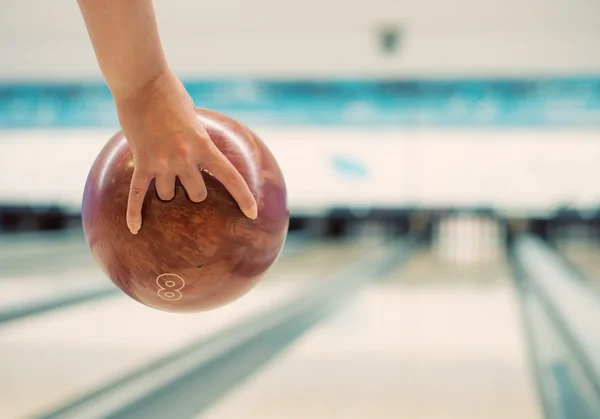 Main de femme jetant la balle dans le club de bowling . — Photo