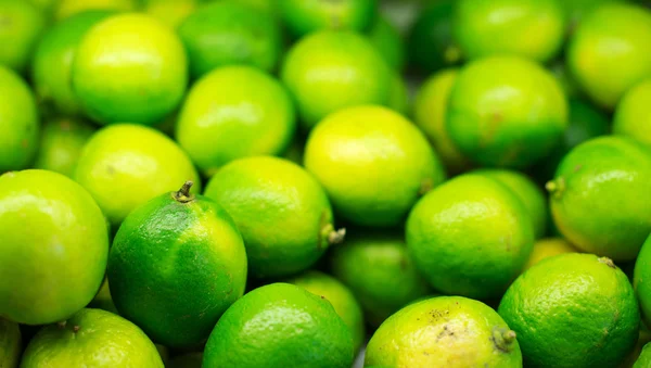 Lots of bright green limes in supermarket. — Stock Photo, Image