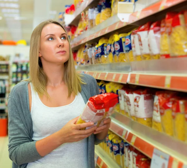 Woman choosing pasta in grocery store. — Stock Photo, Image