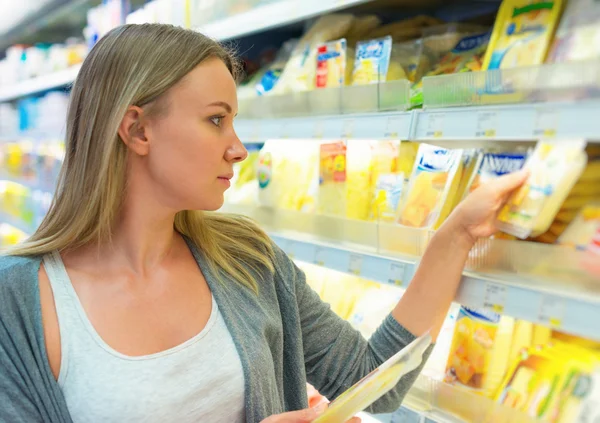 Woman choosing cheese in grocery store. — Stock Photo, Image