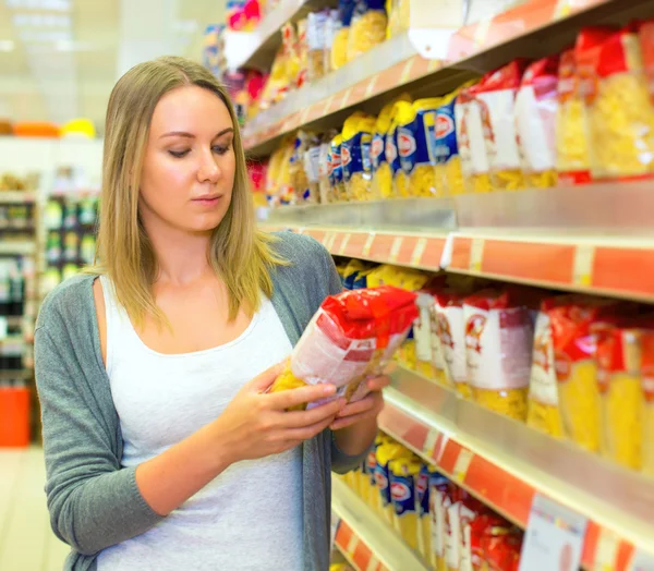 Mulher escolhendo macarrão no supermercado . — Fotografia de Stock