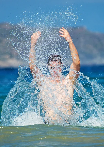 Mężczyzna przelewanie wody z rękami na morzu. — Zdjęcie stockowe
