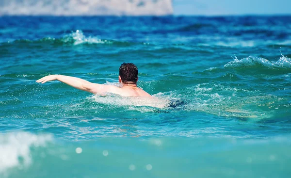 Un uomo che nuota nel mare. Concetto di vacanza . — Foto Stock