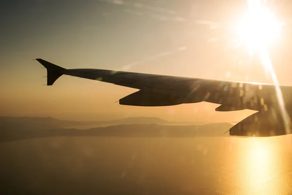 Ala de um avião ao pôr-do-sol, vista da janela . — Fotografia de Stock
