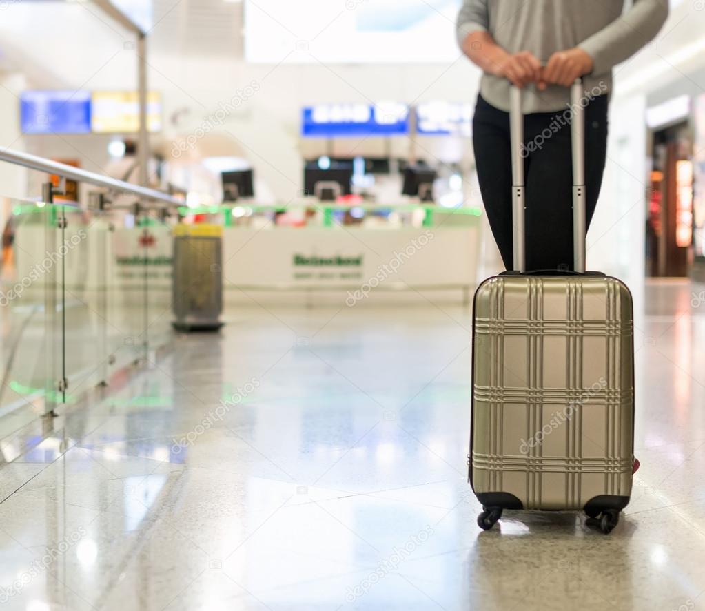 Female passenger with travel bag at the airport. 