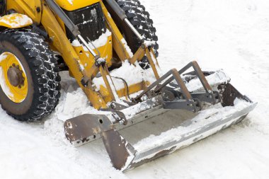 Sokakta kar kürekle traktör.