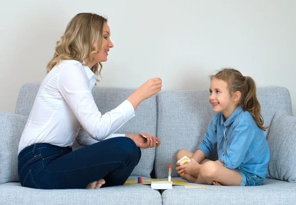 Mãe e filha jogando jogo de tabuleiro em casa . — Fotografia de Stock