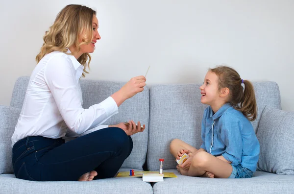 Mãe e filha jogando jogo de tabuleiro em casa . — Fotografia de Stock