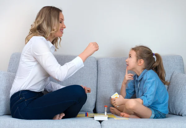 Mãe e filha jogando jogo de tabuleiro em casa . — Fotografia de Stock