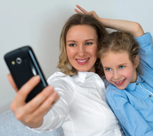 Madre e hija tomando selfie con teléfono móvil . — Foto de Stock