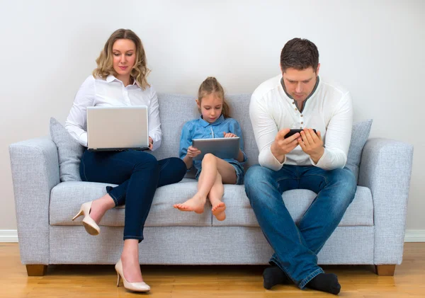 Valores familiares modernos. Pai, mãe e filha usando dispositivos eletrônicos . — Fotografia de Stock