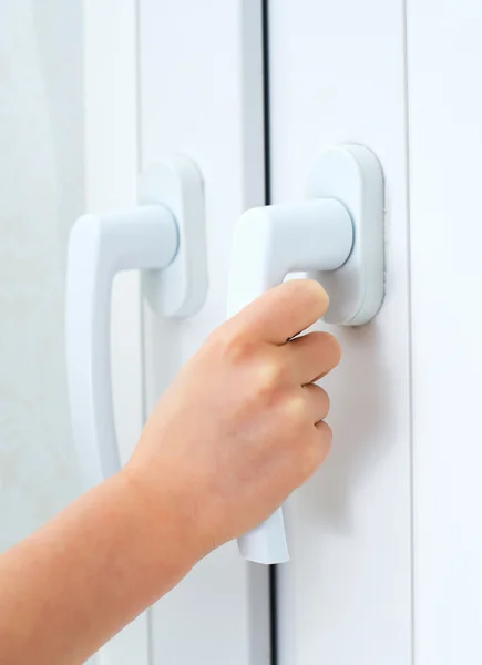 Child tries to open window. Dangerous situation at home. — Stock Photo, Image