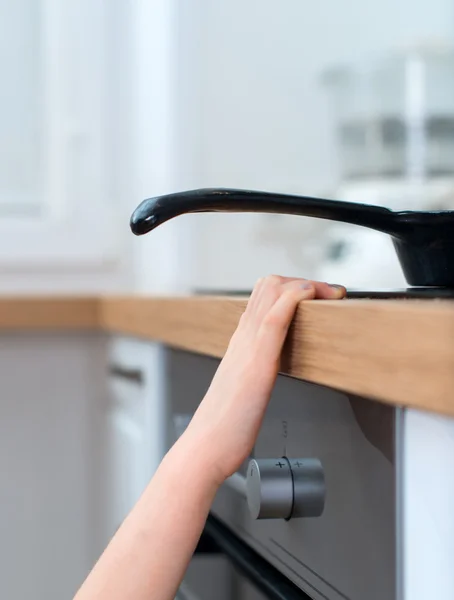 Child touches hot pan on the stove. Dangerous situation at home. — Stock Photo, Image