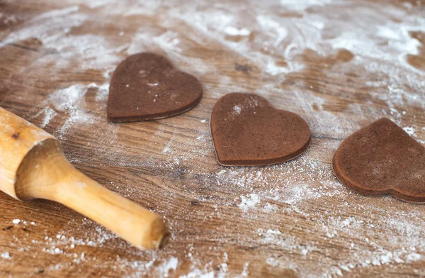 Hjärtformade kakor och kavel på träbord. — Stockfoto