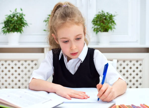 Kleines Mädchen macht ihre Hausaufgaben zu Hause. — Stockfoto