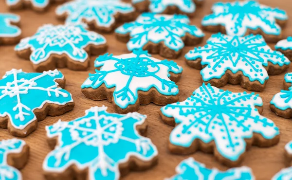 Soubory cookie na vrcholu dřevěný stůl ve tvaru mnoho sněhové vločky. — Stock fotografie