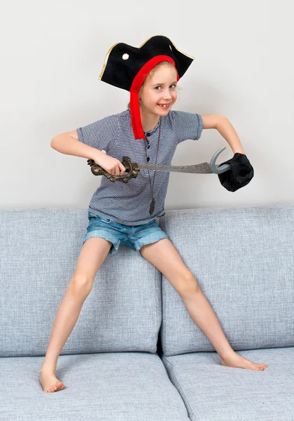 Pirate little girl playing on sofa at home. — Stock Photo, Image