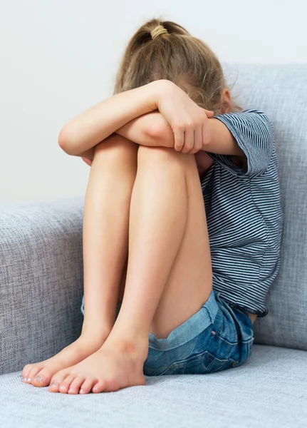 Sad little girl crying on the sofa. — Stock Photo, Image