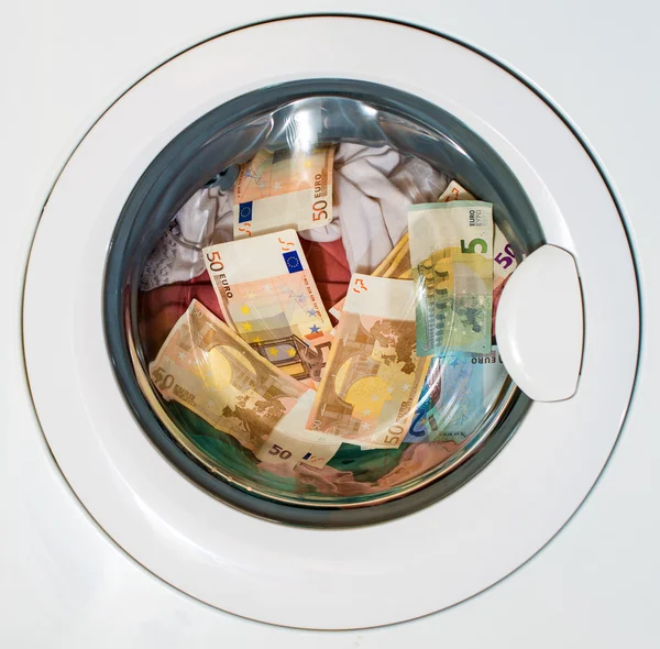 Veel van de euro in de wasmachine. Vuile geld concept. — Stockfoto