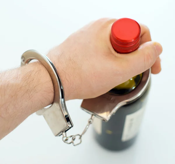 Handschellen an eine Flasche Wein gefesselt. Alkoholismus-Konzept. — Stockfoto