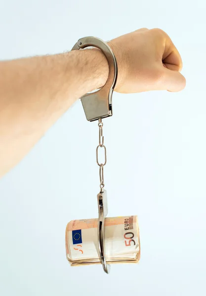 Hand mit Handschellen und Geld. Bestechungskonzept. — Stockfoto