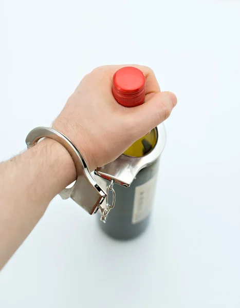 Hand handcuffed to bottle of wine. Alcoholism concept.  Space for text. — Stock Photo, Image