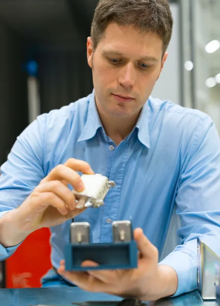 Gutaussehender Arbeiter, der elektronische Komponenten in der Fabrik zusammenbaut. — Stockfoto