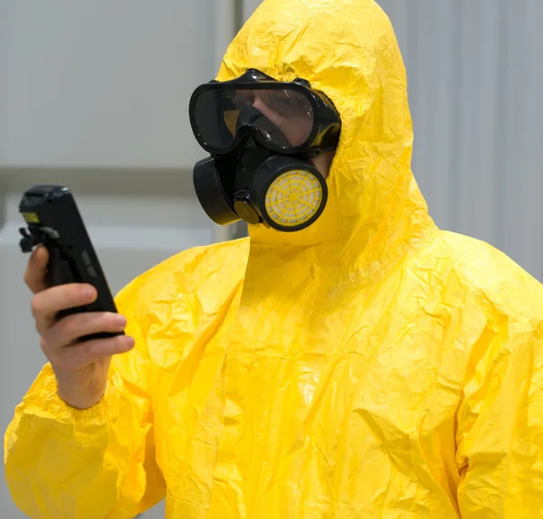 Worker in protective chemical suit checking radiation with geiger counter. — Stock Photo, Image